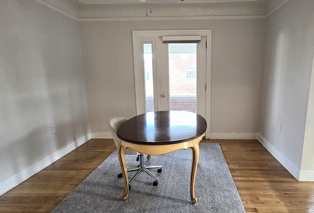 home office featuring wood finished floors, ornamental molding, and baseboards
