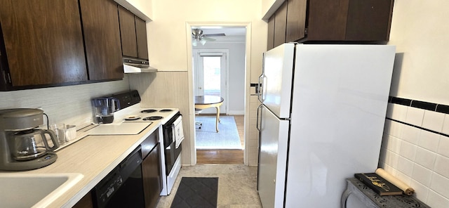 kitchen with dark brown cabinetry, electric stove, freestanding refrigerator, and under cabinet range hood