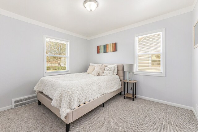 bedroom with carpet, visible vents, ornamental molding, and baseboards