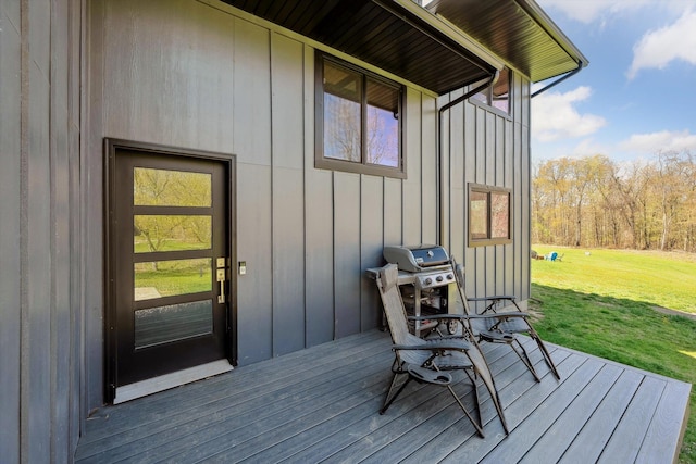 deck with a lawn and area for grilling