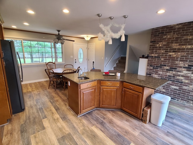 24800 Dayton Rd, Armada, MI 48005 - kitchen featuring freestanding refrigerator, light wood-style floors, a kitchen island, brown cabinets, and a sink