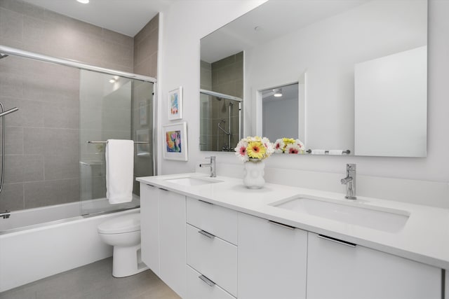 311 Alfred St, Detroit, MI 48201 - bathroom featuring double vanity, toilet, shower / bath combination with glass door, and a sink