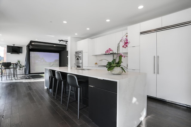 311 Alfred St, Detroit, MI 48201 - kitchen with modern cabinets, light countertops, dark wood-style floors, and recessed lighting