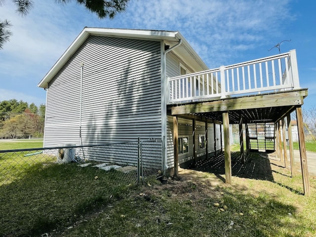 view of side of property featuring a deck and fence