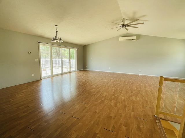 unfurnished room featuring an AC wall unit, ceiling fan with notable chandelier, lofted ceiling, and wood finished floors