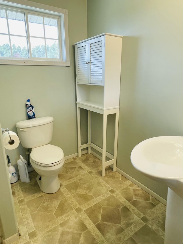 bathroom featuring toilet and baseboards