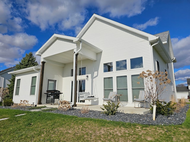 back of property with a lawn and a patio area