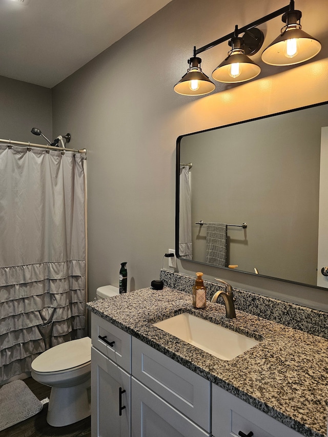 bathroom featuring a shower with shower curtain, toilet, and vanity