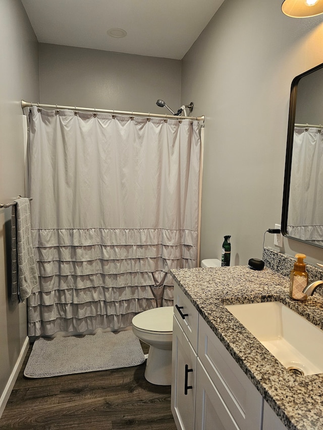 bathroom featuring toilet, vanity, a shower with curtain, and wood finished floors