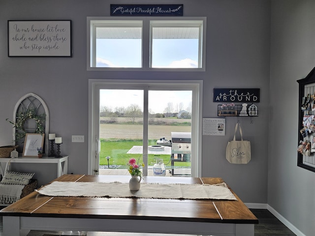 dining area featuring dark wood-type flooring and baseboards