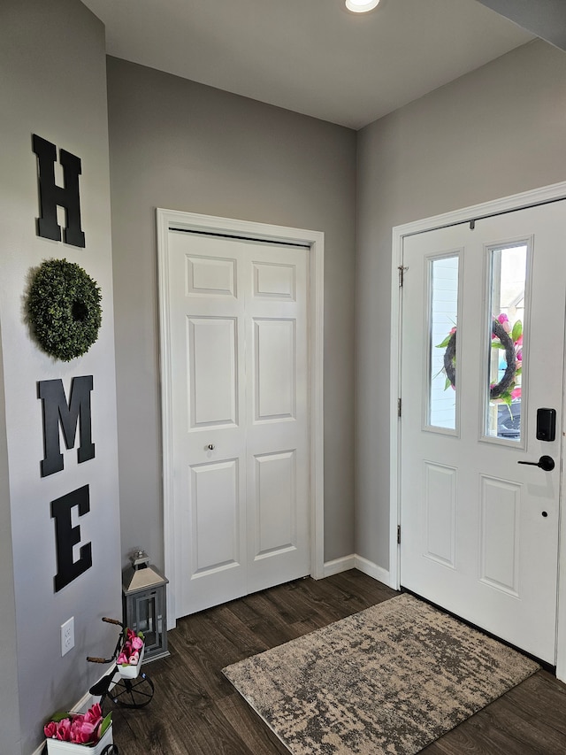 entrance foyer featuring dark wood finished floors and baseboards