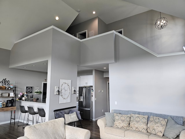 living area featuring a towering ceiling, a chandelier, baseboards, recessed lighting, and dark wood-type flooring