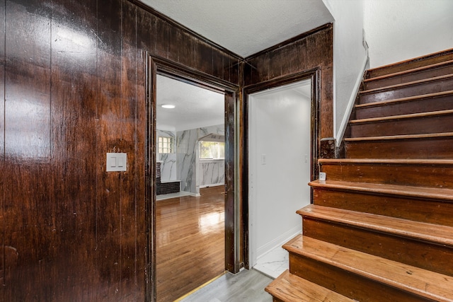 stairway with wood finished floors and baseboards