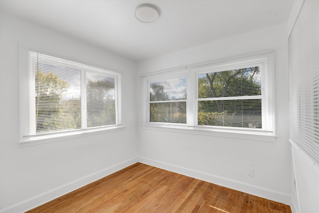 spare room with light wood-style floors and baseboards