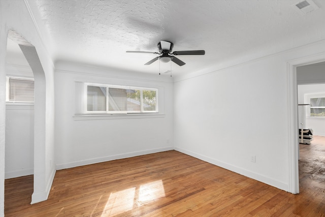 unfurnished bedroom featuring baseboards, visible vents, a ceiling fan, and light wood-style floors