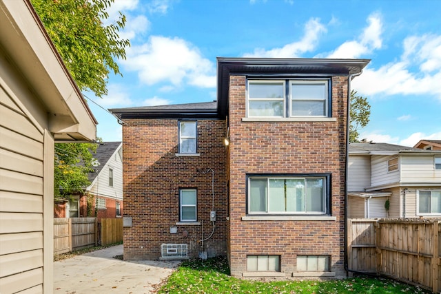 rear view of house featuring a patio, a fenced backyard, and brick siding
