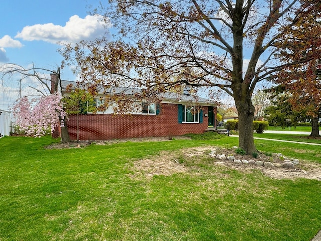 view of side of home with a chimney and a yard