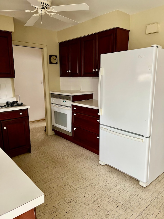 kitchen featuring light countertops, ceiling fan, white appliances, and reddish brown cabinets