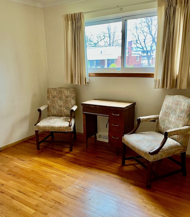 sitting room with baseboards and light wood-type flooring