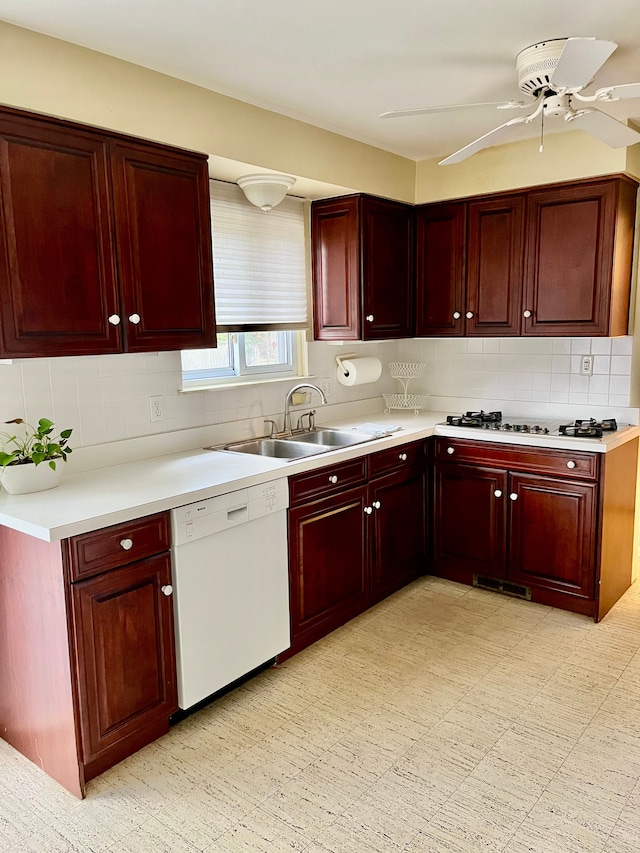 kitchen featuring white appliances, a sink, and reddish brown cabinets