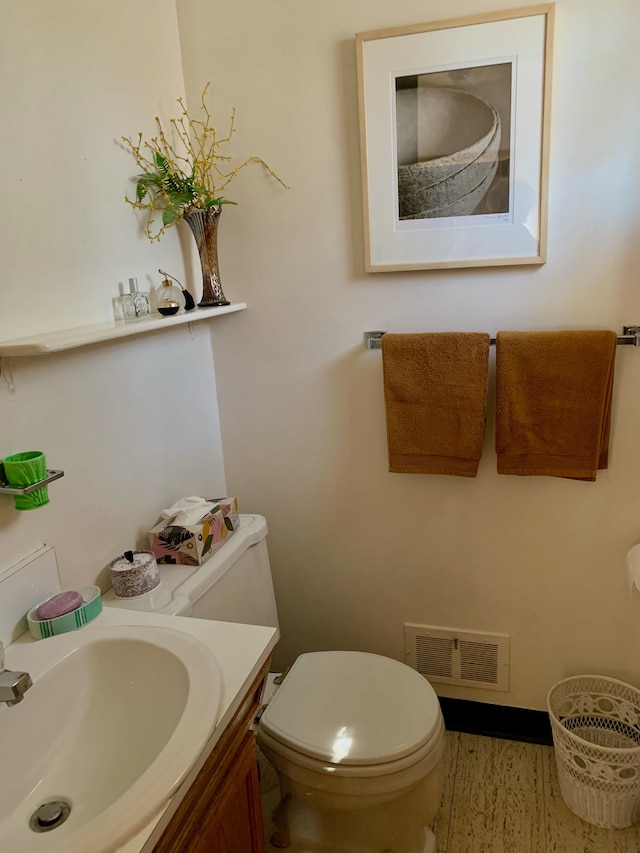 bathroom featuring visible vents, toilet, and vanity