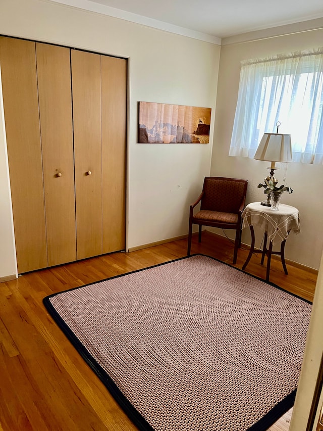bedroom with crown molding, a closet, and light wood finished floors