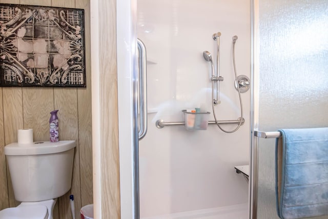 full bath featuring a shower stall and toilet