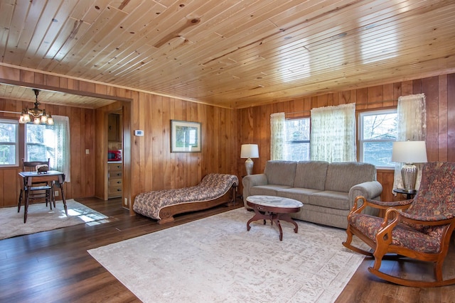 living room featuring wood walls, a notable chandelier, wooden ceiling, and a wealth of natural light