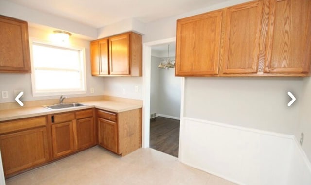 22613 Raven Ave, Eastpointe, MI 48021 - kitchen with light countertops, brown cabinetry, and a sink