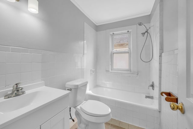 full bath featuring tiled shower / bath, tile walls, toilet, vanity, and crown molding