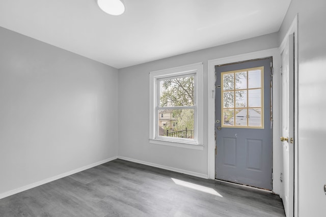 doorway with wood finished floors and baseboards