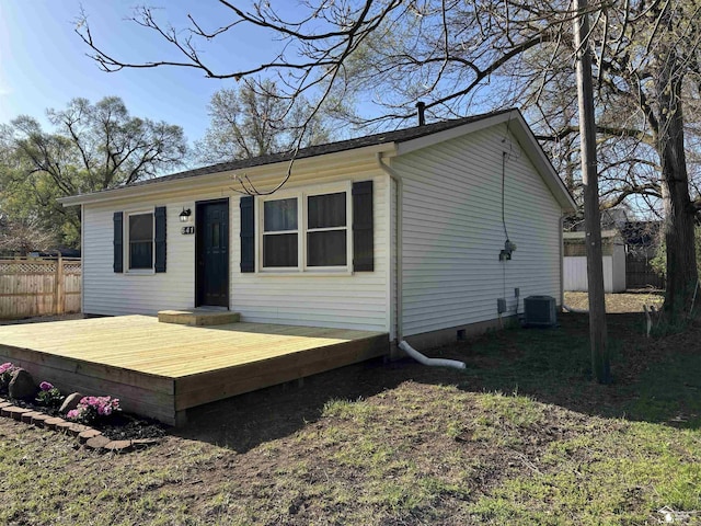 rear view of house with fence, a deck, and crawl space