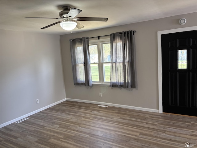 foyer entrance with visible vents, ceiling fan, wood finished floors, and baseboards