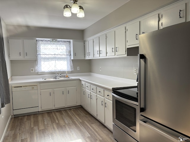 kitchen with a sink, stainless steel appliances, light wood-type flooring, light countertops, and white cabinets