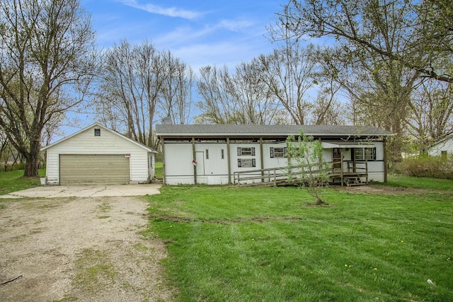 view of front of property featuring a garage, an outbuilding, and a front yard