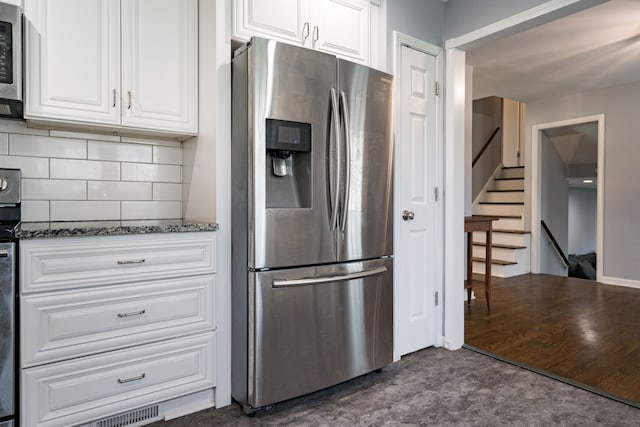 29742 Old Bedford St, Farmington Hills, MI 48331 - kitchen with stainless steel appliances, dark stone counters, white cabinetry, and backsplash