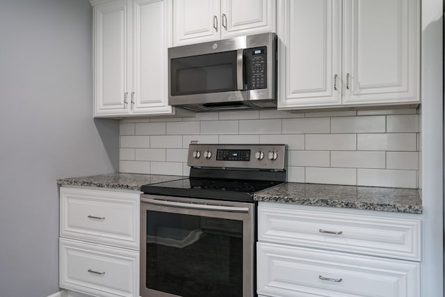 29742 Old Bedford St, Farmington Hills, MI 48331 - kitchen featuring appliances with stainless steel finishes, decorative backsplash, white cabinets, and dark stone counters