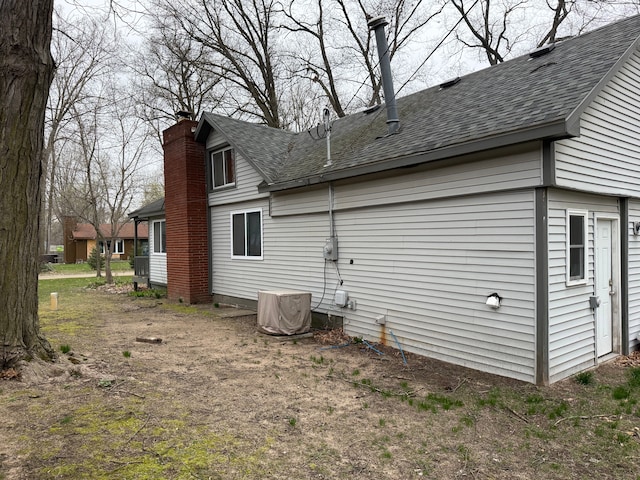 2976 Giddings Blvd, Highland, MI 48356 - view of home's exterior with a chimney and a shingled roof