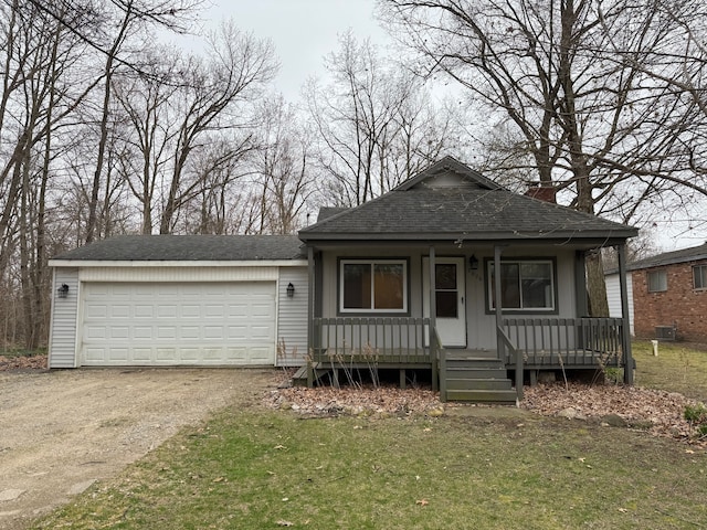 view of front of house featuring a chimney, a porch, a shingled roof, a garage, and driveway