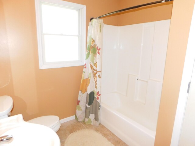 full bath with shower / tub combo with curtain, toilet, tile patterned flooring, and baseboards