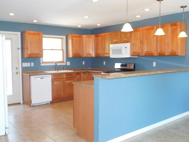 kitchen featuring brown cabinets, a sink, white appliances, a peninsula, and hanging light fixtures