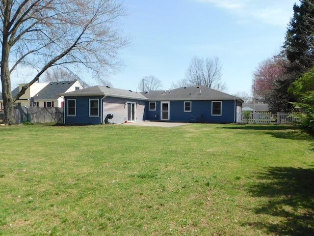 rear view of house with a patio, a yard, and fence