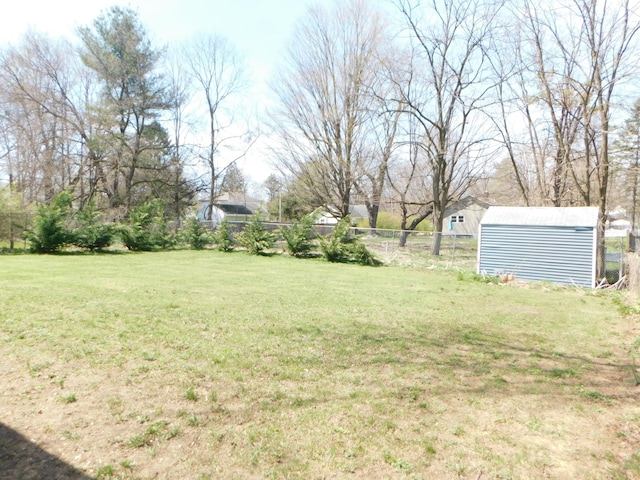 view of yard with an outbuilding, a storage shed, and fence