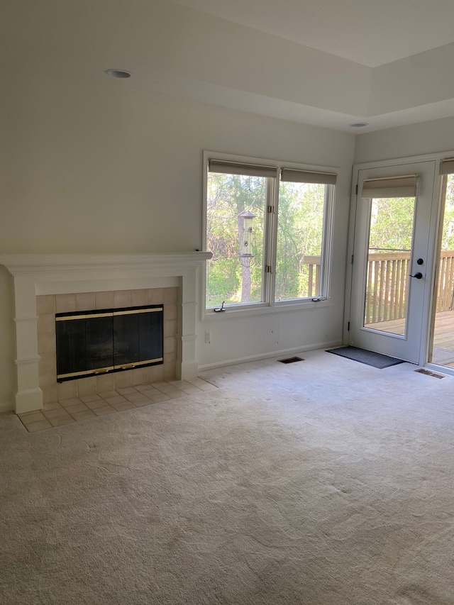 unfurnished living room featuring baseboards, visible vents, carpet floors, and a fireplace