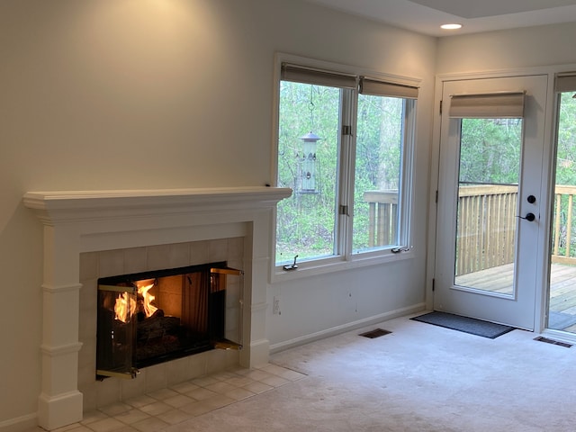 doorway to outside featuring recessed lighting, carpet flooring, a fireplace, visible vents, and baseboards