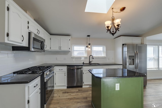 kitchen featuring an inviting chandelier, a sink, appliances with stainless steel finishes, and a wealth of natural light
