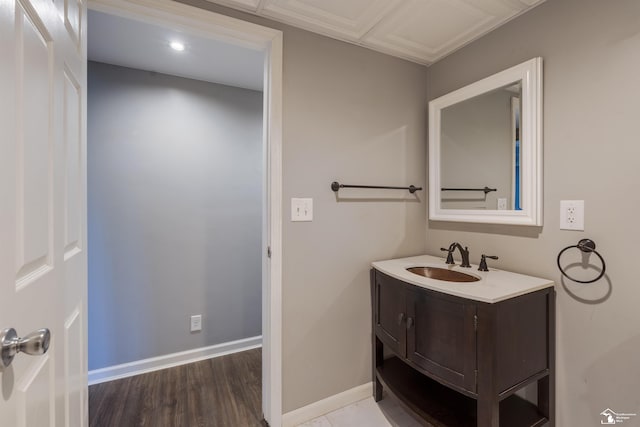 bathroom with wood finished floors, vanity, and baseboards