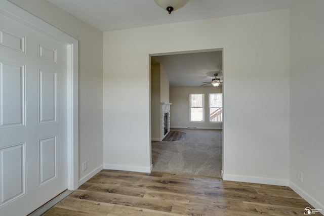 hall featuring baseboards and wood finished floors