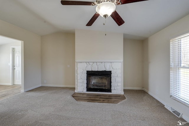 unfurnished living room featuring a wealth of natural light, visible vents, ceiling fan, and carpet floors