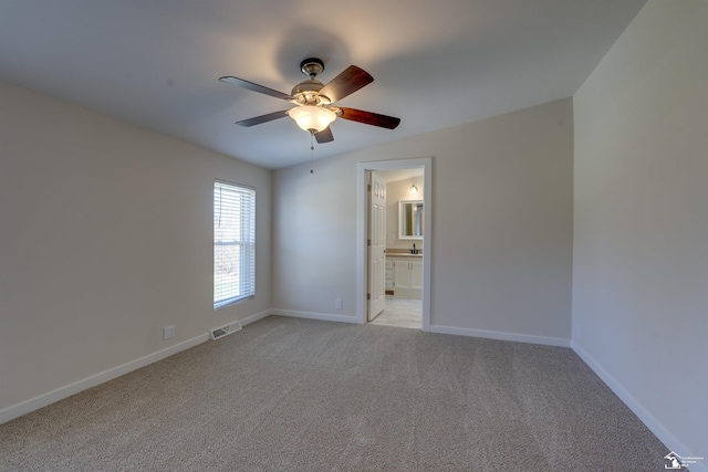 unfurnished room featuring visible vents, a ceiling fan, baseboards, and light carpet